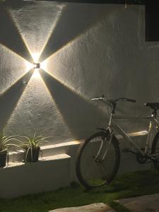 a bike parked next to a wall with a light at Sapphire Stayss in Yelagiri