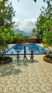 a picnic table in front of a swimming pool at Jasmine Resort Kampot in Kampot