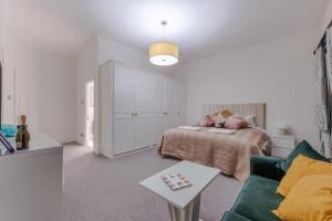 Habitación blanca con cama y sofá en Harley Street Spectacular Suites with High Ceilings, High Luxury, en Londres