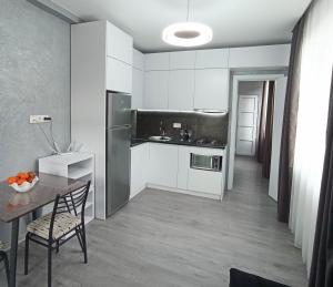 a kitchen with white cabinets and a table and a dining room at Studio in Chakvi in Chakvi