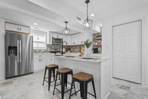 a kitchen with white cabinets and a island with stools at Newly Renovated Modern Farmhouse in Culpeper