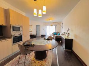 eine Küche und ein Wohnzimmer mit einem Tisch im Zimmer in der Unterkunft Room 1 Salina Seaview Retreat in Naxxar