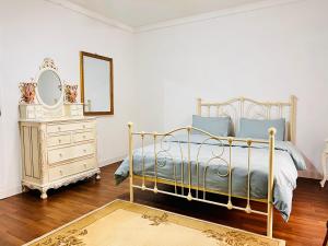 een slaapkamer met een bed, een dressoir en een spiegel bij Room 1 Salina Seaview Retreat in Naxxar