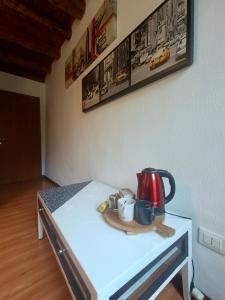 einen Tisch mit einem Wasserkocher und Tassen darauf in der Unterkunft Borgo Lungofiume B&B in Valbrenta 