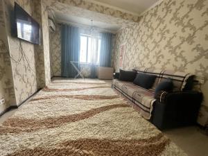 een woonkamer met een bank en een groot tapijt bij Center Cozy Apartment in Bisjkek