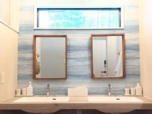 La salle de bains est pourvue de 2 lavabos et de 2 miroirs. dans l'établissement プライベートサウナがあるGuestHouseレビッキ【水上駅】より徒歩10分【水上IC】より車7分, à Minakami