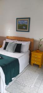 una camera con un grande letto e un comodino di Recanto do Turista a Chapada dos Guimarães