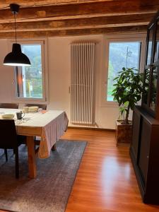 a dining room with a table and two windows at Borgo Lungofiume B&B in Valbrenta 