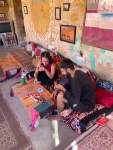 um homem e uma mulher sentados no chão numa sala em Marigold Homestay em Jaisalmer
