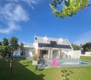 a house with a pink flamingo in the yard at THE SURF AND GOLF HUIS Solar Power in St Francis Bay