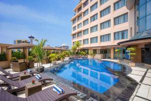 a swimming pool in front of a hotel at Hotel Ciputra Semarang managed by Swiss-Belhotel International in Semarang