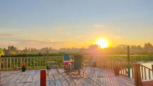 a deck with chairs and a table at sunset at Houseboat wild rose in Srinagar