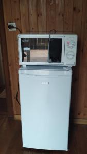 un forno a microonde seduto sopra un frigorifero bianco di B&B SòT AL PIZ a Sagron Mis