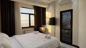 杜尚別的住宿－Hotel Panorama，卧室配有白色的床和窗户。