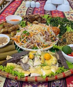 un vassoio di cibo sopra un tavolo di Mai Chau Moonlight Ecohouse a Mai Châu