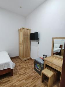 a bedroom with a bed and a desk and a mirror at Cát Tâm Hotel in Quy Nhon