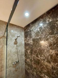 a bathroom with a shower with a stone wall at Appart neuf calme et bien équipé in Casablanca