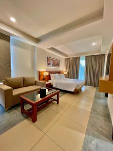 een hotelkamer met een bed, een bank en een tafel bij Best Western Maharani Bagh New Delhi in New Delhi