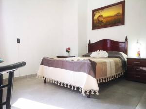 ein Schlafzimmer mit einem Bett und einem Wandgemälde in der Unterkunft Casa Judá in San Cristóbal de las Casas