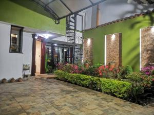 ein grünes und weißes Gebäude mit Blumen und Pflanzen in der Unterkunft Casa Judá in San Cristóbal de las Casas