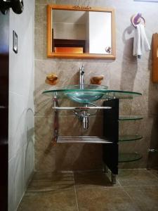 ein Badezimmer mit einem Glaswaschbecken und einem Spiegel in der Unterkunft Casa Judá in San Cristóbal de las Casas