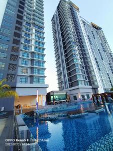 twee hoge gebouwen naast een zwembad met twee gebouwen bij FR Studio Seaview Imperium Residence in Kuantan