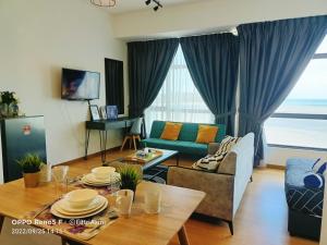 een woonkamer met een bank en een tafel bij FR Studio Seaview Imperium Residence in Kuantan