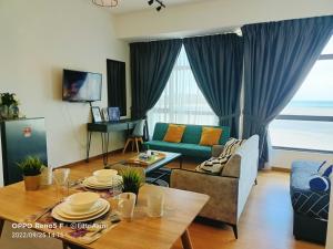 una sala de estar con un sofá y una mesa en FR Studio Seaview Imperium Residence, en Kuantan