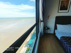 een slaapkamer met uitzicht op de oceaan vanuit een raam bij FR Studio Seaview Imperium Residence in Kuantan