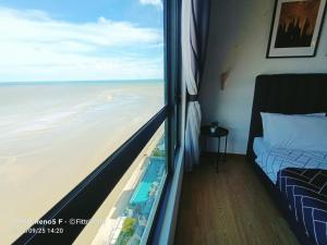 1 dormitorio con vistas al océano desde una ventana en FR Studio Seaview Imperium Residence, en Kuantan