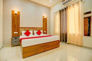 a bedroom with a large bed with red pillows at Super OYO Flagship Hotel Elista in Zirakpur