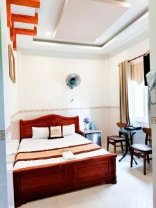 1 dormitorio con cama de madera en una habitación en Khách Sạn Tuyết Linh Lý Sơn, en Quảng Ngãi