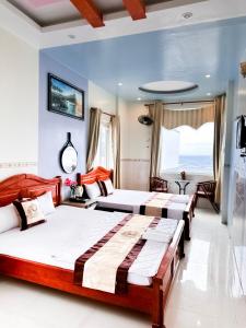 2 łóżka w pokoju hotelowym z widokiem na ocean w obiekcie Khách Sạn Tuyết Linh Lý Sơn w mieście Quang Ngai