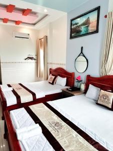 een slaapkamer met 2 bedden en een spiegel bij Khách Sạn Tuyết Linh Lý Sơn in Quang Ngai