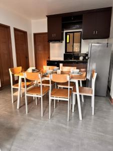 a kitchen with a table and chairs and a refrigerator at Dano Private Resort and Apartments in Dauis