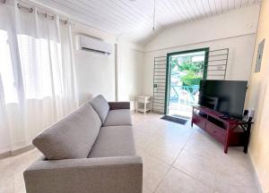 a living room with a couch and a flat screen tv at Beach Walk in Saint James