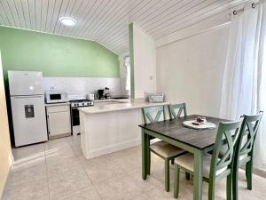 a kitchen with a table and chairs and a refrigerator at Beach Walk in Saint James