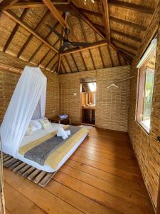 um quarto com uma cama num quarto com pisos em madeira em Floating Paradise em Karimunjawa