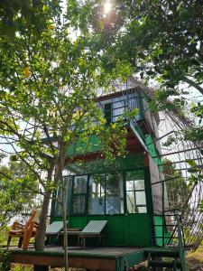 a building with a tree and benches in front of it at LA'S FARMSTAY in Tây Ninh