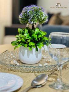 une table avec un vase avec des fleurs violettes dans l'établissement Comfortable 2-roomed apartment Ozod Apartments, à Samarcande