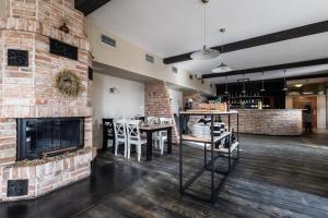 a living room with a fireplace and tables and chairs at Hotel Tanzberg Mikulov in Mikulov