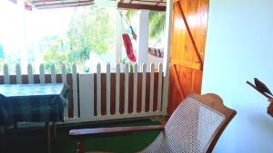 uma mesa e uma cadeira num quarto com uma cerca em New Farmers Paradise em Ella