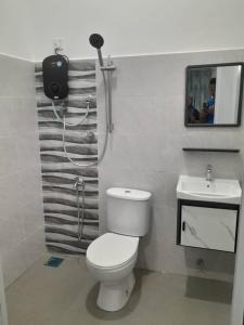 a bathroom with a toilet and a sink at Ocean Cottage 2, Radiant Teluk Sari in Kampung Mawar