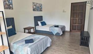 a room with two beds and a door at Ocean Cottage 2, Radiant Teluk Sari in Kampung Mawar