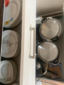 a cupboard filled with plates and pans at Faakersee Seahouse mit Privat Strand -Only Sa-Sa in Faak am See