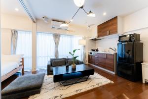 a living room with a couch a table and a kitchen at SAKURA Residence目黒駅前 Standard in Tokyo