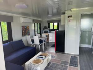 a living room with a blue couch and a kitchen at Country Tracks in Willowbank