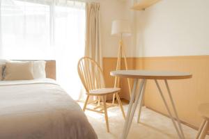 東京にあるunito residence HIKAWADAIのベッドルーム1室(ベッド1台、テーブル、椅子付)