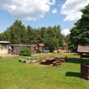 um grupo de mesas de piquenique e um parque infantil num campo em Siedlisko U Ani em Skrzynki