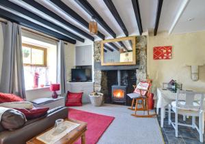 sala de estar con sofá y chimenea en Mynydd Annedd Cottage en Beddgelert